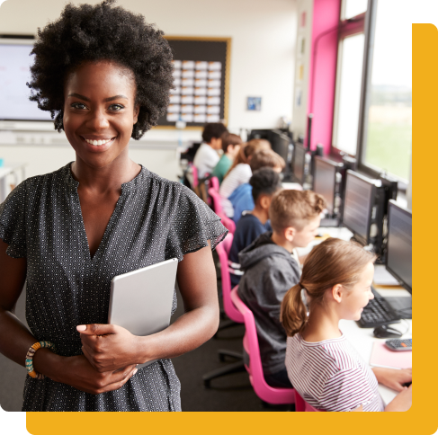 Teacher smiling while students work on computers